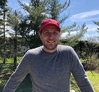 BJ Wojtowicz House Chef outside smiling with Cornell Dining Hat on head