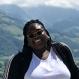 Christy Atangana Headshot smiling mountains in the background
