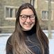 Anna Poslednik headshot smiling building in background snow on ground
